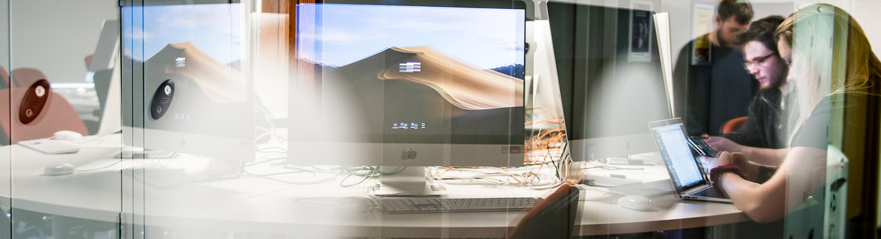 Marketing students working at a bank of computers.