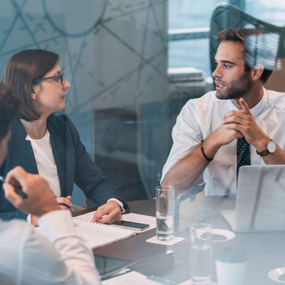 A male and a female talking in a business meeting.