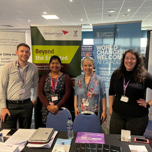 : Dr Peter Tormey (ENU), Dr Linda J Thomas (ENU), Dr Sarah Sholl (ENU), Amy McDermott (University of Glasgow) standing in front of banners at the Career Transition Partnership (CTP) Employment fair.
