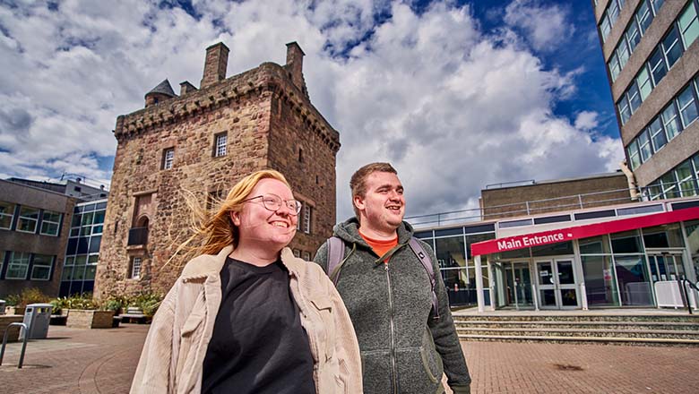 Two students walking through the Merchiston quad.