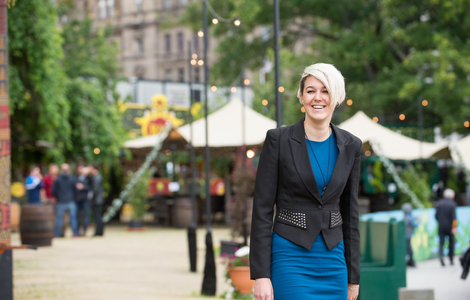 Student smiling as she walks through a decorated festival street