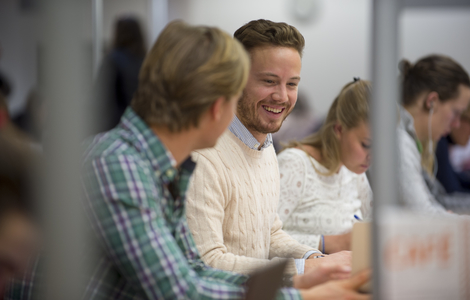 Photo of students smiling while working together