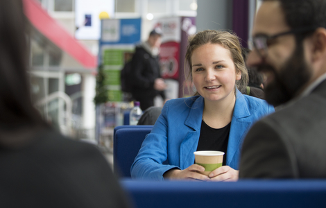 International business student smiling whilst listening to someone speak