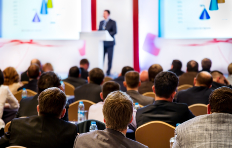 Speaker at a conference in front of a crowd