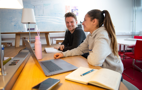 Two students smiling as they study