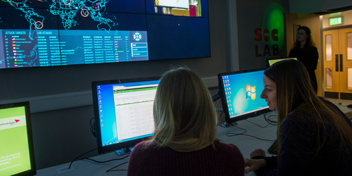 Two female students in the SOC lab looking at computers