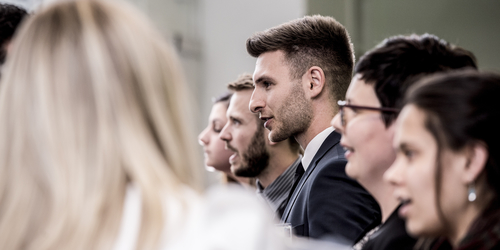 Edinburgh Napier University students in a row chatting to business people at an industry event.