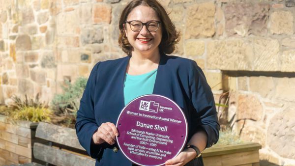 Front cover star Danae Shell holding a purple plaque