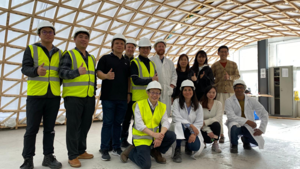Crew in front of bamboo structure