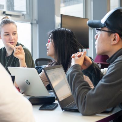 Three people working at their laptops