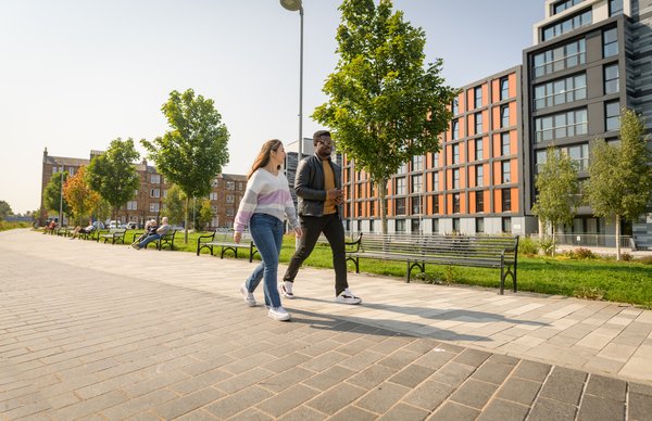 Two students from Edinburgh Napier University walking by our Bainfield student accommodation in city centre Edinburgh on a warm summers day. 
