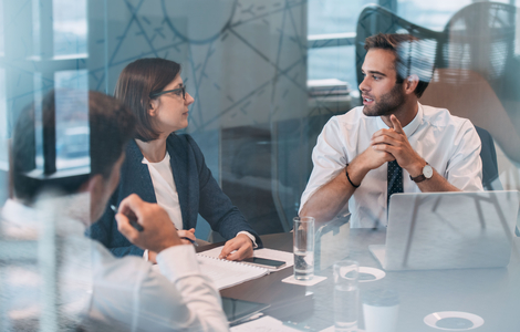 Group of business people talking together while working around a table at a meeting