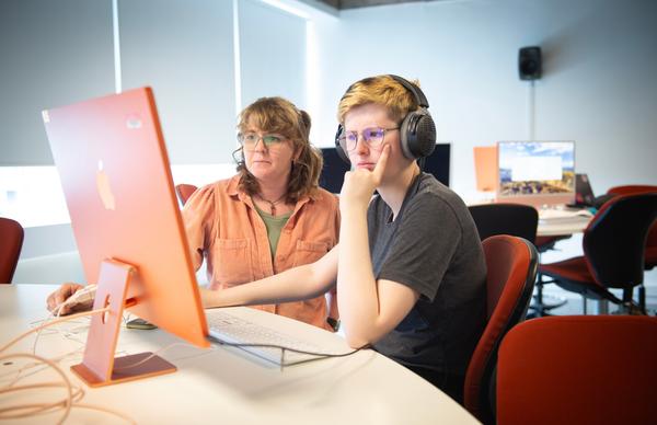 Student and academic working together in the Edinburgh Napier University computer labs at Merchiston campus. 