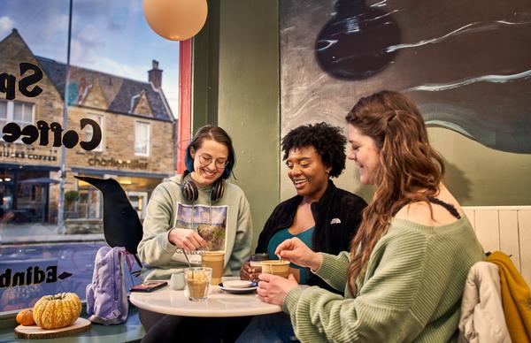 Three students from Edinburgh Napier University conversing in one of Edinburgh's many cafés.