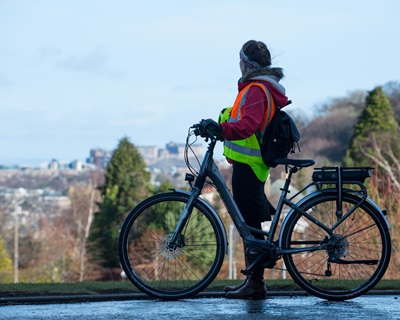 A woman with an electric bike at Edinburgh Napier University's Craiglockhart campus
