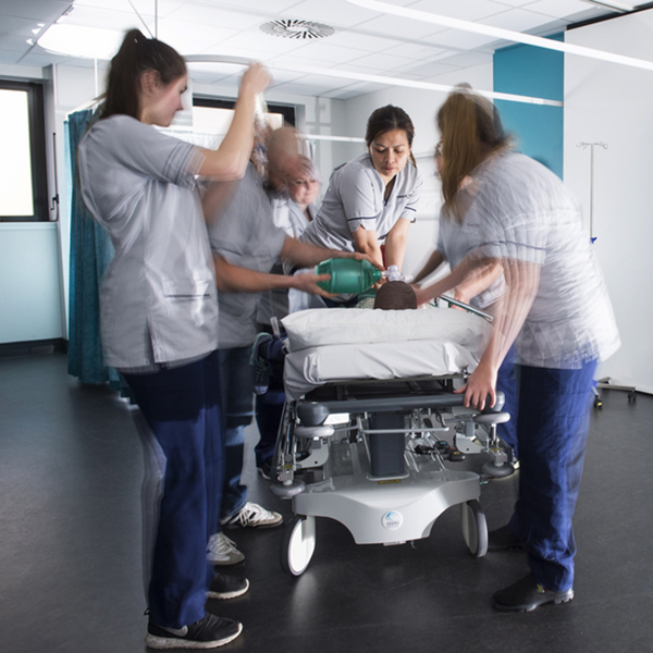 Four student nurses around a model of a patient in the clinical skills simulation centre