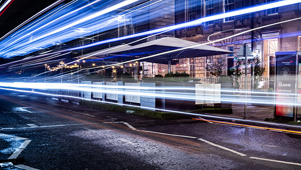 Slow shutter speed image of light streaks down a central Edinburgh street