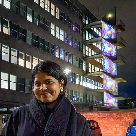Design student in front of Blue Monday lighting event at Merchiston campus
